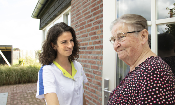 Client mevrouw Schoondermark bij de voordeur samen met wijkverpleegkundige Bente Senders.
